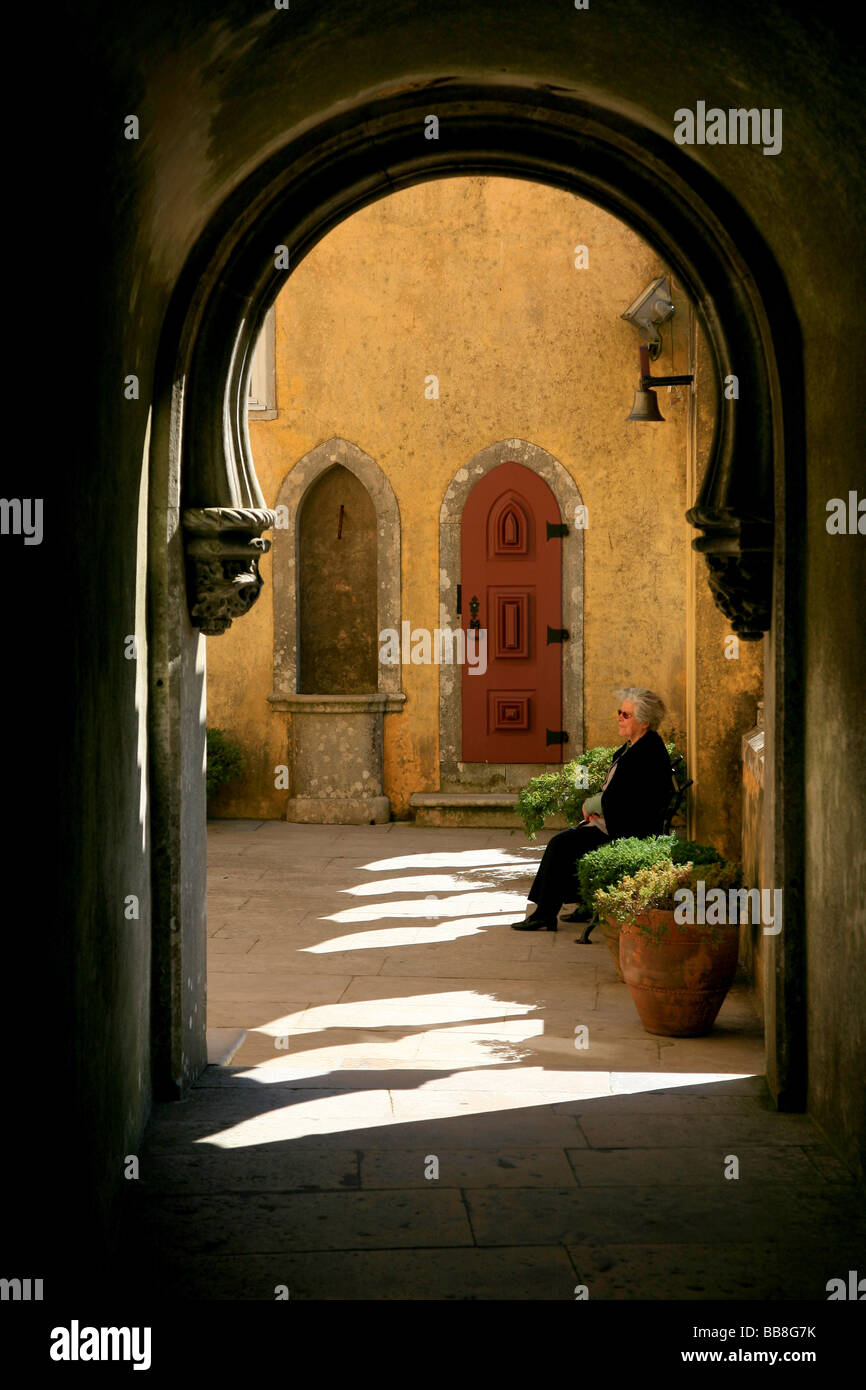 Elderly lady relaxing on a bench in the courtyard at the Pena National Palace Stock Photo