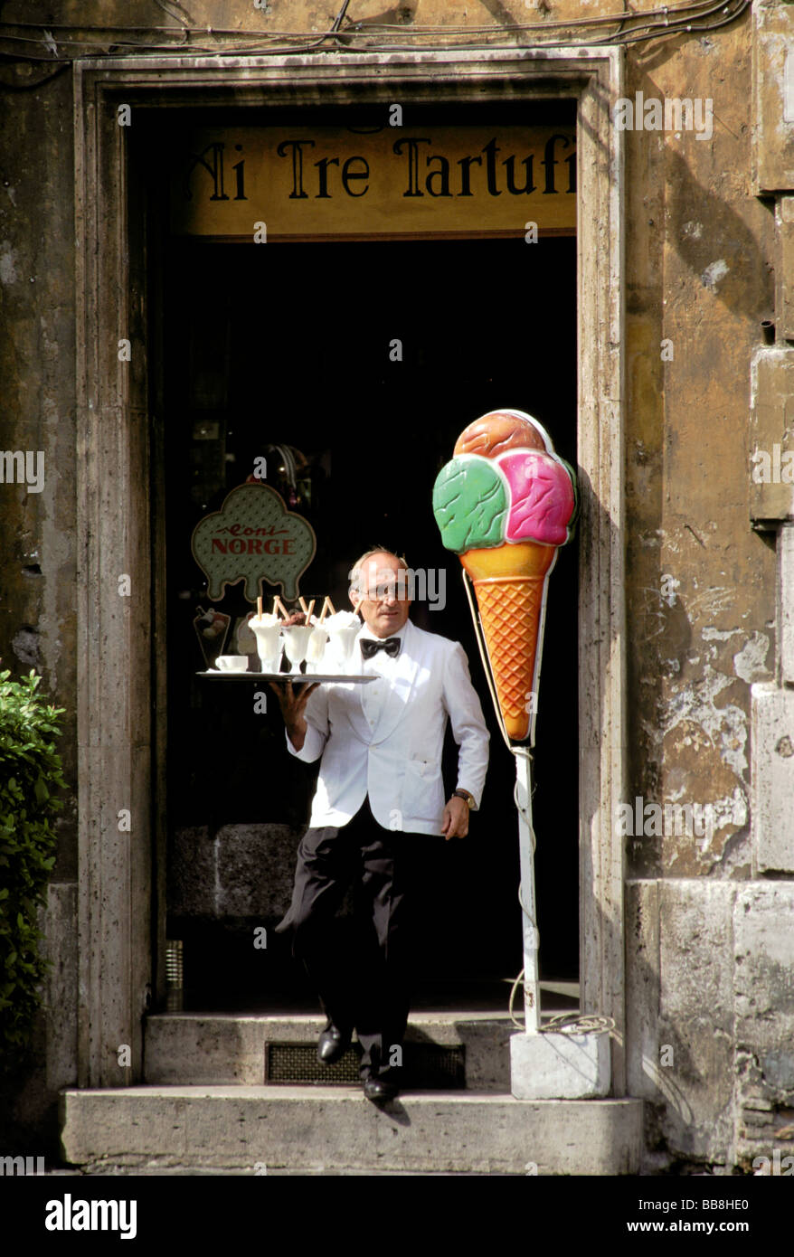 A waiter serves ice cream and drinks from a small cafe, Piazza Navona, Rome, Italy Stock Photo