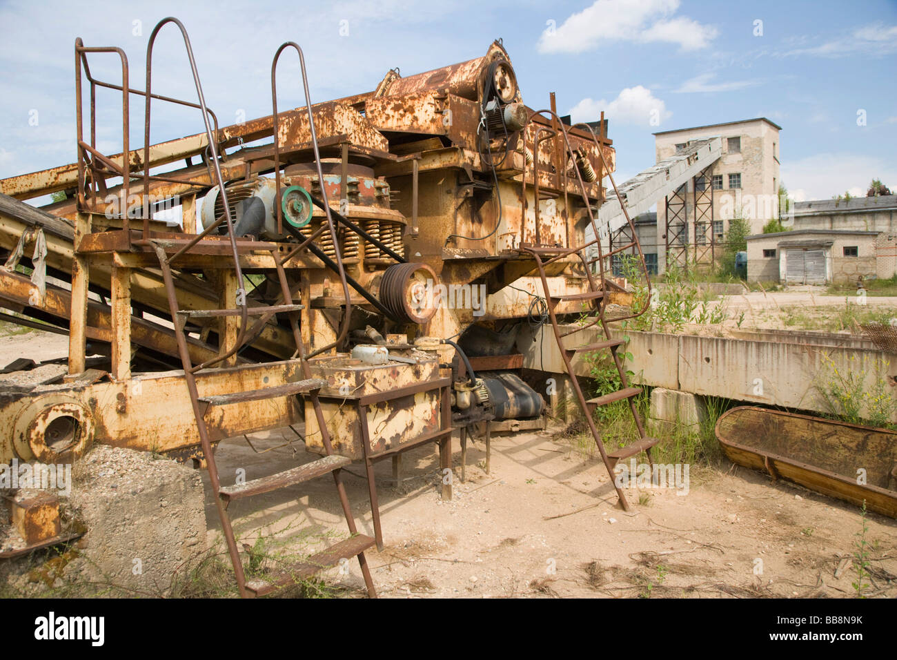 Old rusted mechanism with driving shafts and belt, remains of Soviet industrial estate, Preili district, Latgalia, Latvia Stock Photo