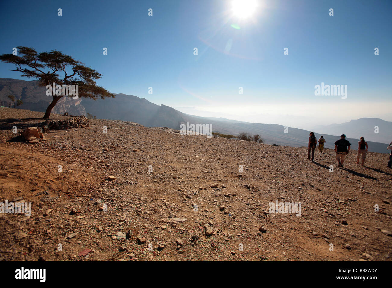 A group of tourists walking to the edge of Jebel Shams in Oman Stock Photo
