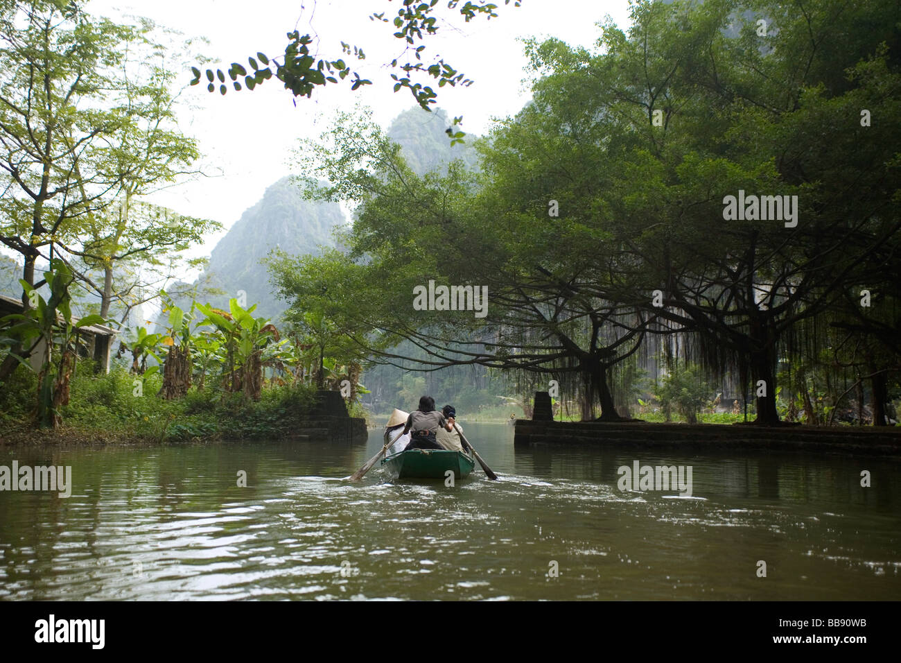 Rowboats on the river and in caves on the Ngo Dong River at Tam Coc near  Ninh Binh Vietnam Stock Photo