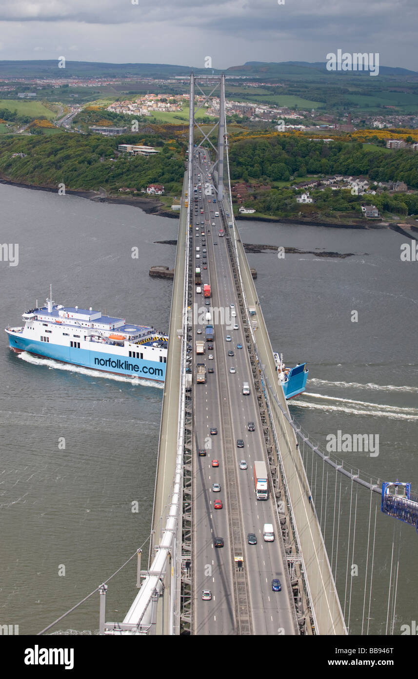 A ferry passes under the Forth Road Bridge on the Firth of Forth, near Edinburgh, Scotland. Stock Photo