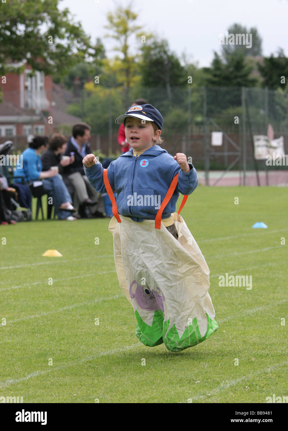 Boy in sack race on grass field on school sports day Stock Photo