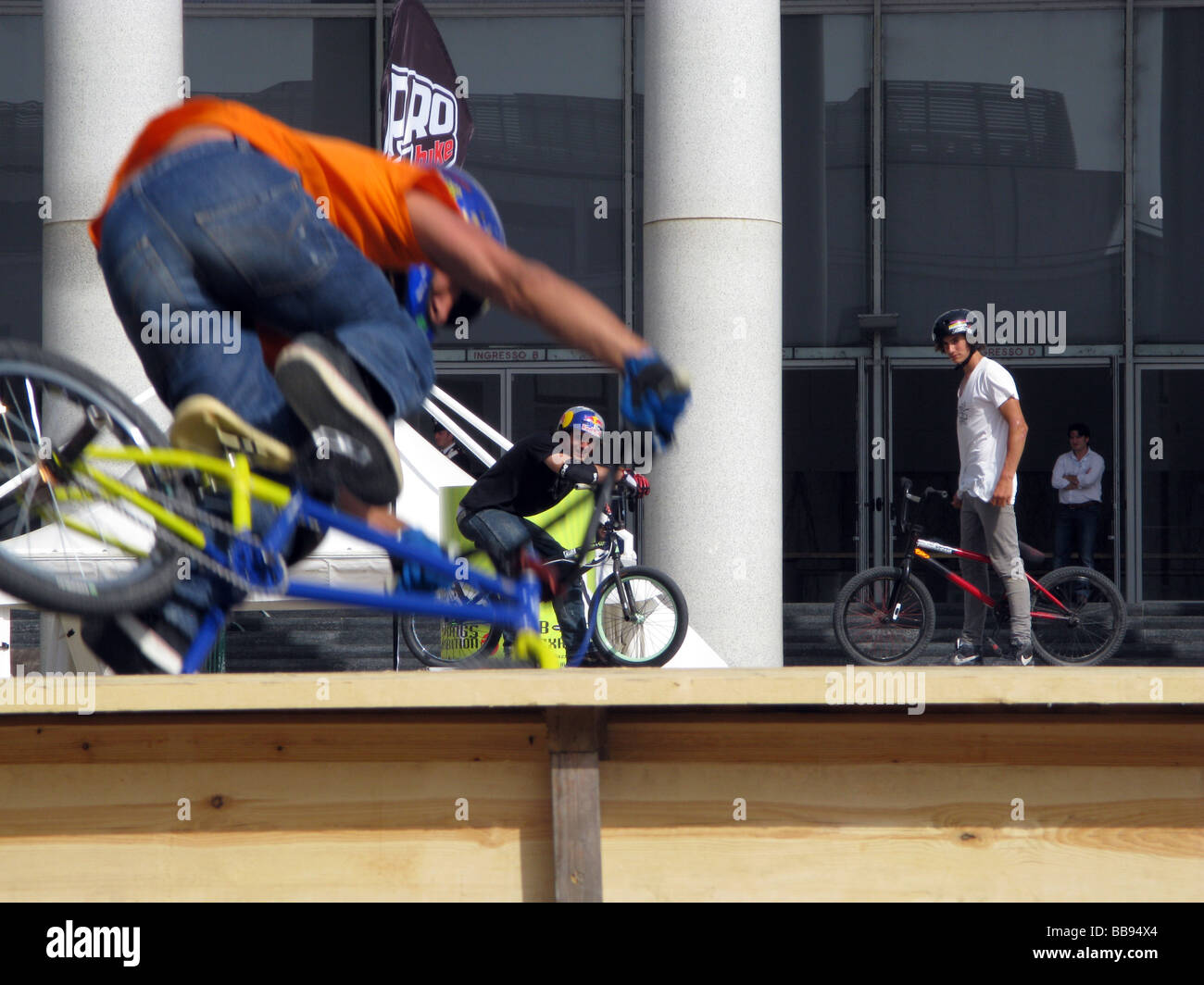 three people doing bike stunts on ramp at event outdoors Stock Photo ...