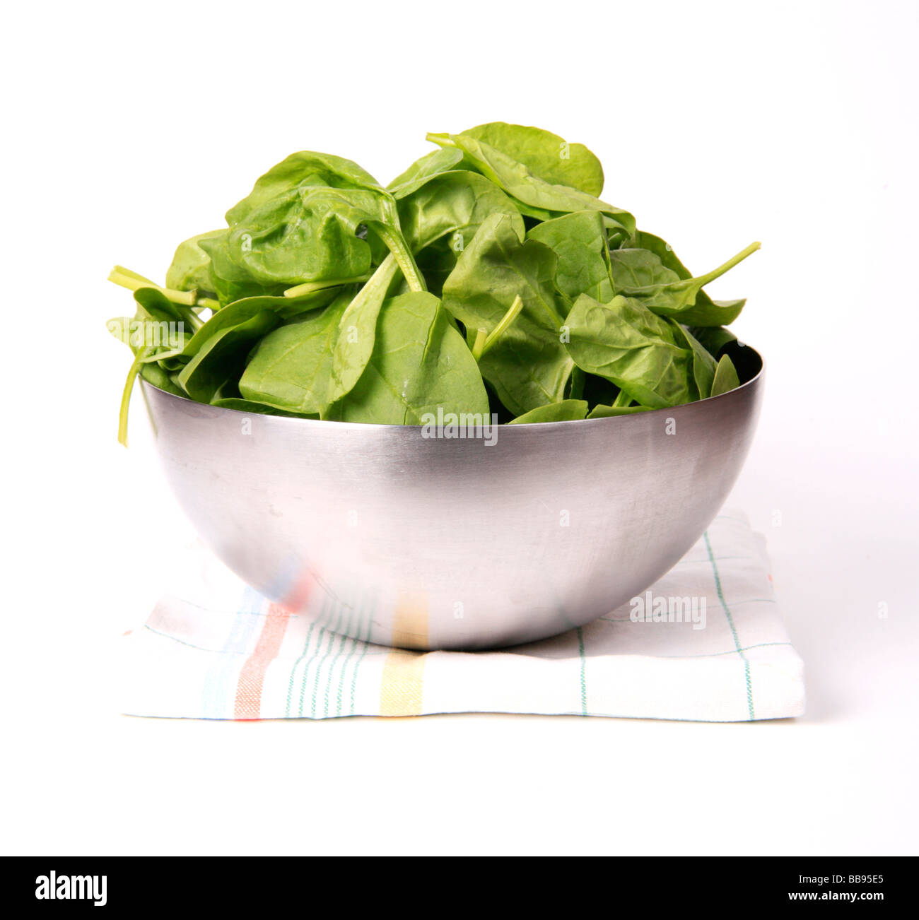 Baby Leaf Spinach in a Stainless Steel Bowl on a white background Stock Photo