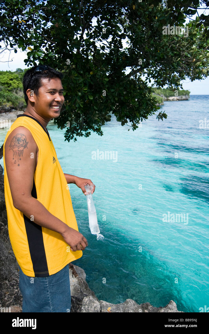 Guide holding a plastic bag full of water, overlooking a popular cliff-jumping spot on Siquijor island in the Philippines Stock Photo