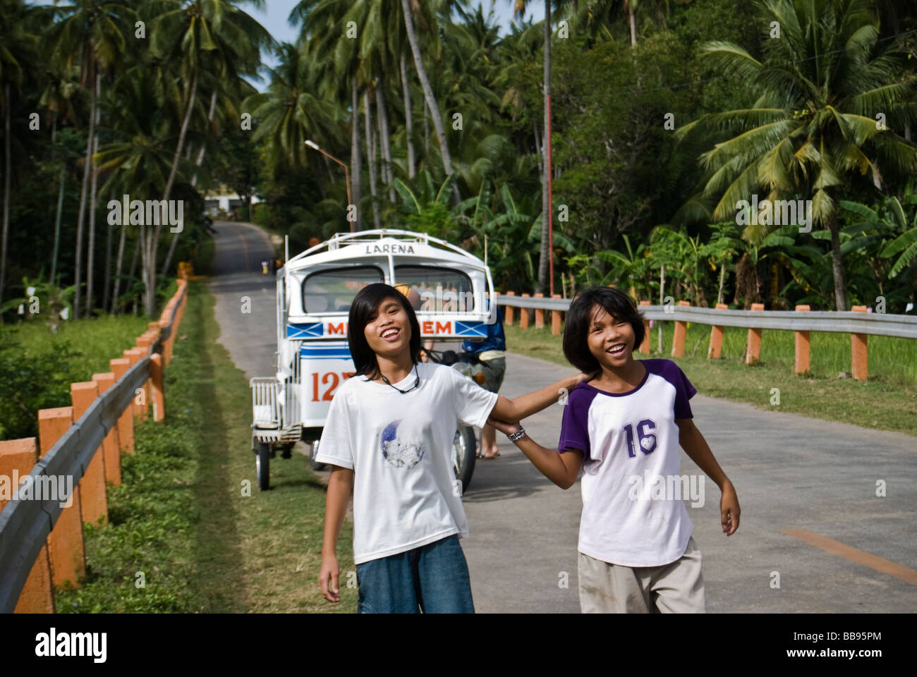 Smiling girls walking along the road in Siquijor, Philippines Stock Photo