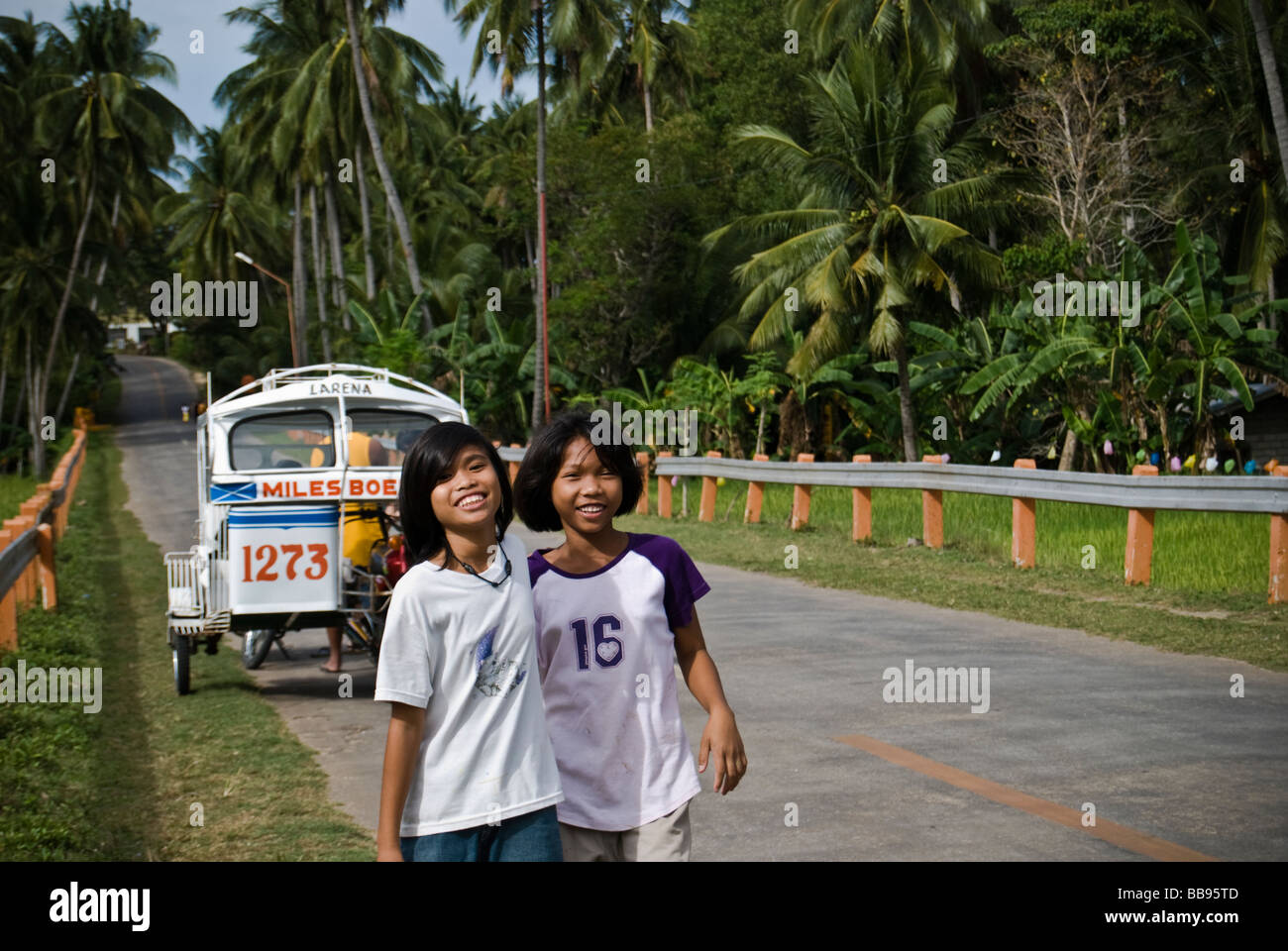 Smiling girls walking along the road in Siquijor, Philippines Stock Photo