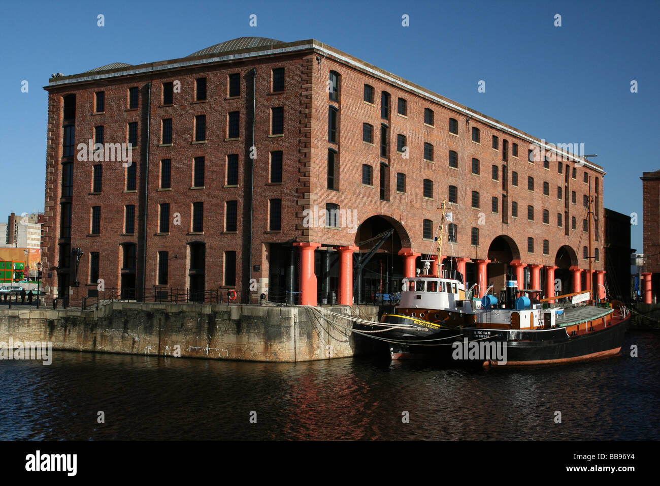 Old Warehouse Buildings And Tug Boats At The Albert Dock, Liverpool, Merseyside, UK Stock Photo
