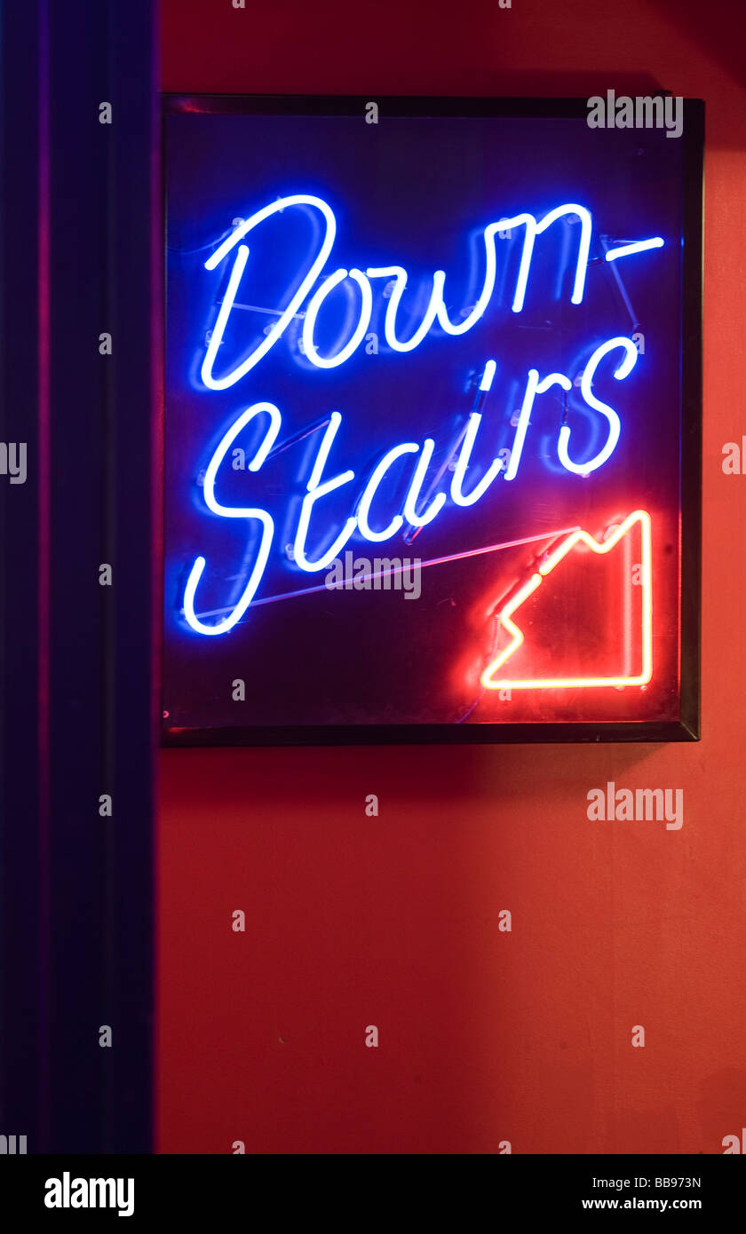 Downstairs Neon Sign with Arrow Stock Photo