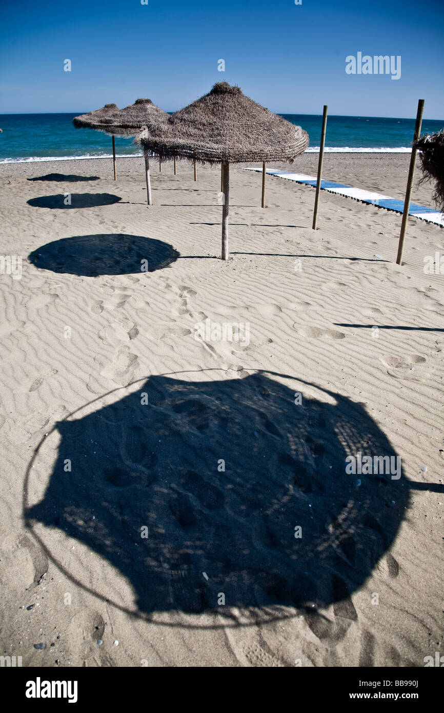 Beach Shades on Cancelada beach Estapona Spain These are permantly errected Straw Beach Umbrellas Stock Photo