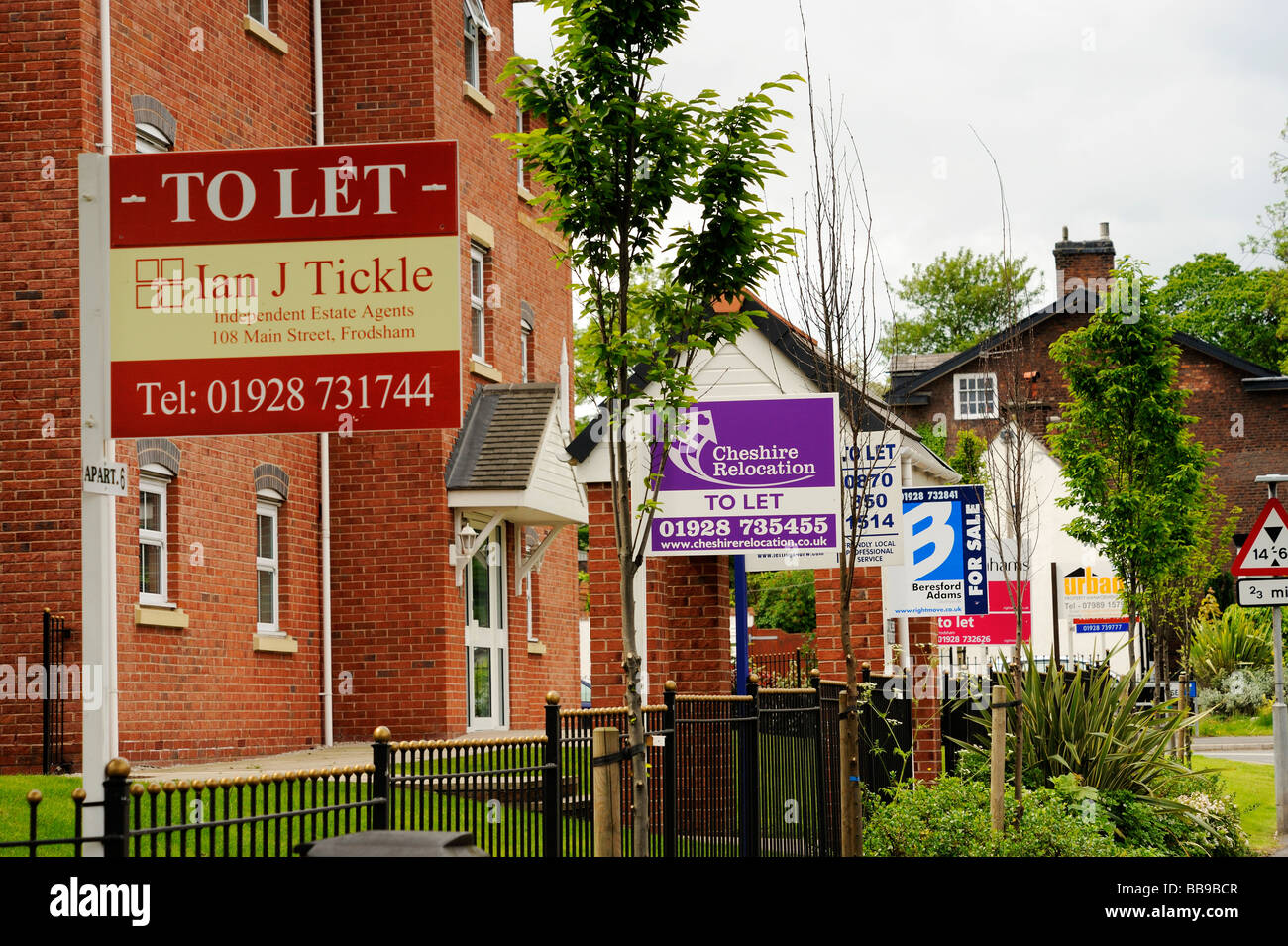 For Sale and 'To Let' signs from various local estate agents outside a