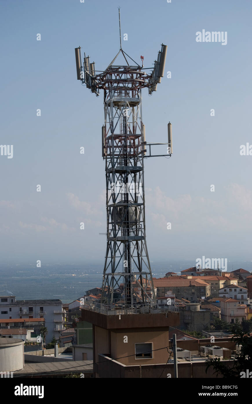 AN ANTENNA FOR TELECOMMUNICATIONS POSITIONED ABOVE THE HOUSES Stock Photo