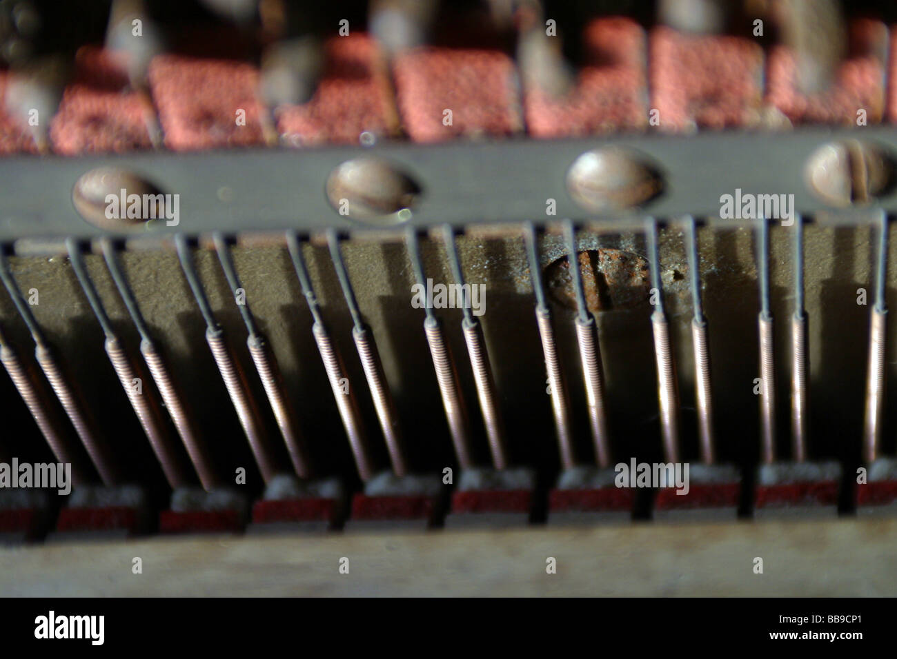 Inside of a upright piano showing tension strings dampers and felt