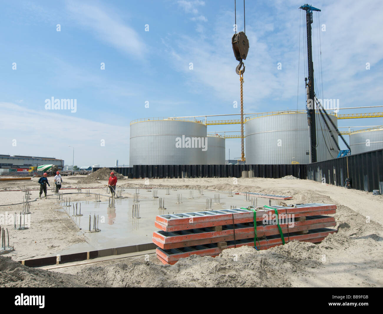 Men constructing a concrete floor foundation for a large fuel storage tank Botlek Zuid Holland the Netherlands Stock Photo