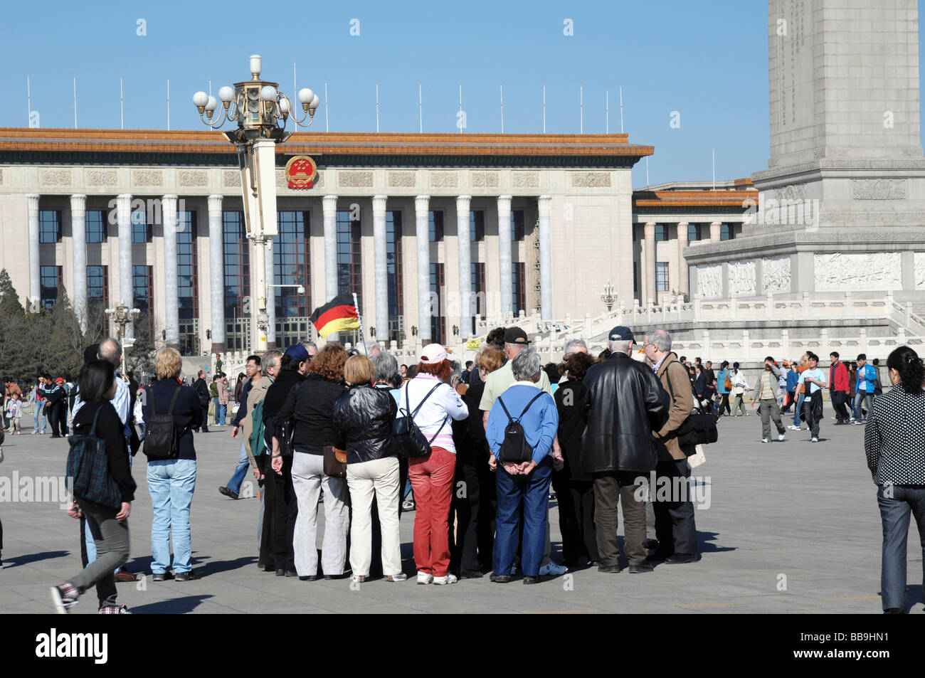 German tourist group on Tiananmen Square, Beijing, China. Great Hall of the People in the background. Stock Photo