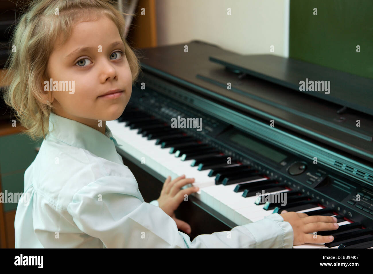 Little caucasian girl play on a electric piano Stock Photo Alamy
