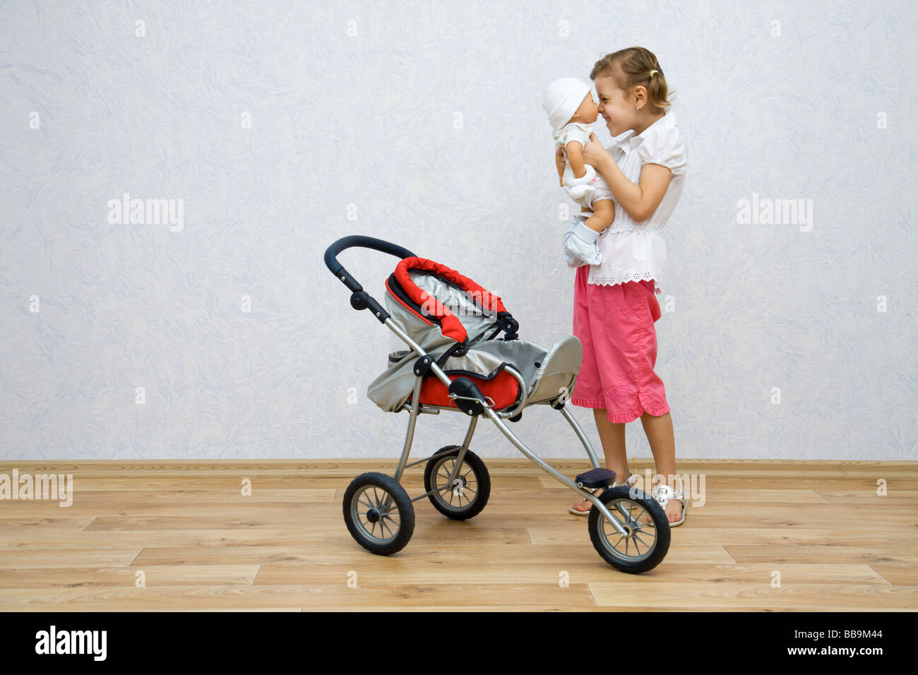 Little pretty caucasian girl playing with doll Stock Photo - Alamy
