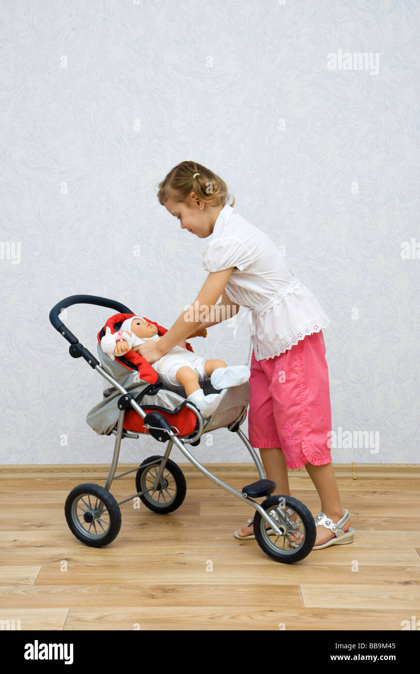 Little pretty caucasian girl playing with doll Stock Photo - Alamy