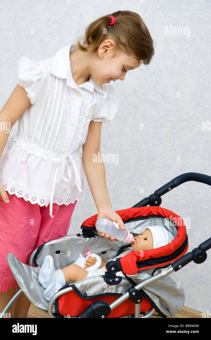 Little pretty caucasian girl playing with doll Stock Photo - Alamy