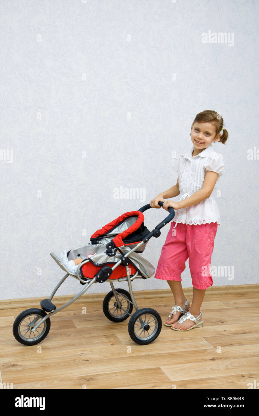 Little pretty caucasian girl playing with doll Stock Photo - Alamy