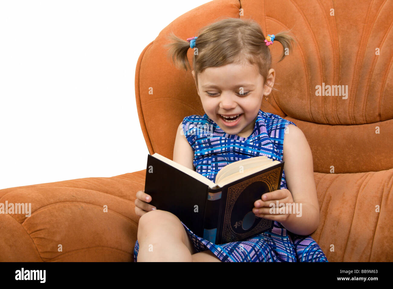 Little girl reading book and have fun Stock Photo - Alamy