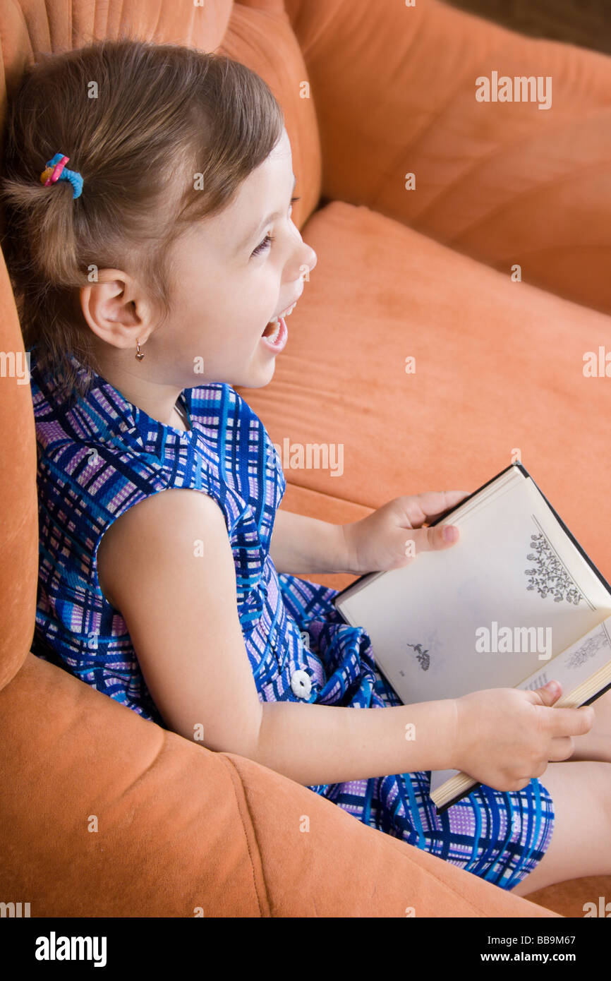 Little girl reading book and have fun Stock Photo - Alamy