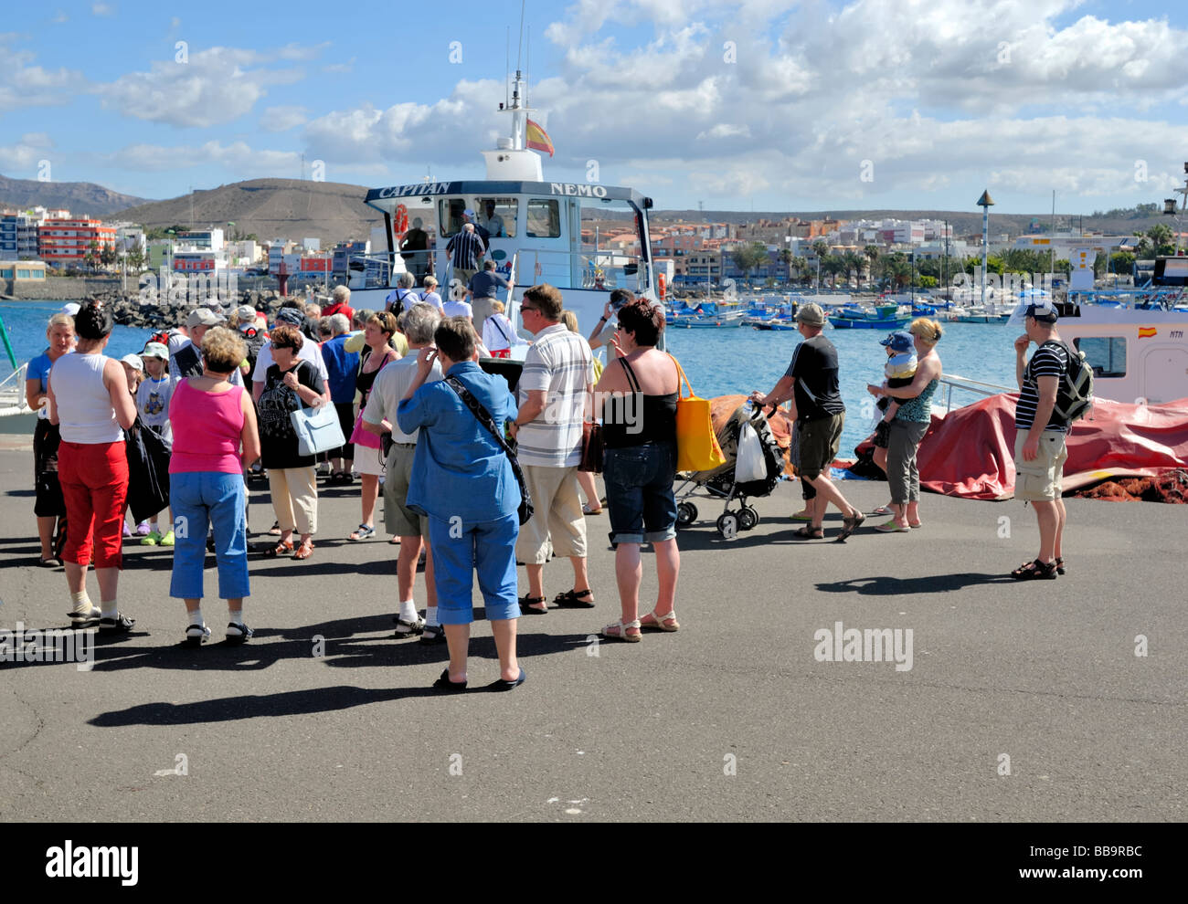 A tourist group have arrived to the port of Arguineguin to go to the tuesday market in Arguineguin village. Gran Canaria, Spain. Stock Photo