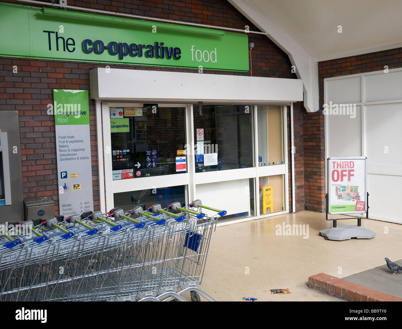 Entrance to a co operative supermarket with trolleys Stock Photo