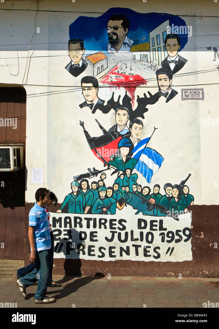 Local Nicaraguan youth walk by Sandinista murals on Avenida Sur Oeste Leon Nicaragua Stock Photo