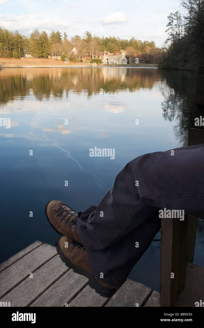 Person sitting on dock by lake - Brevard, North Carolina Stock Photo