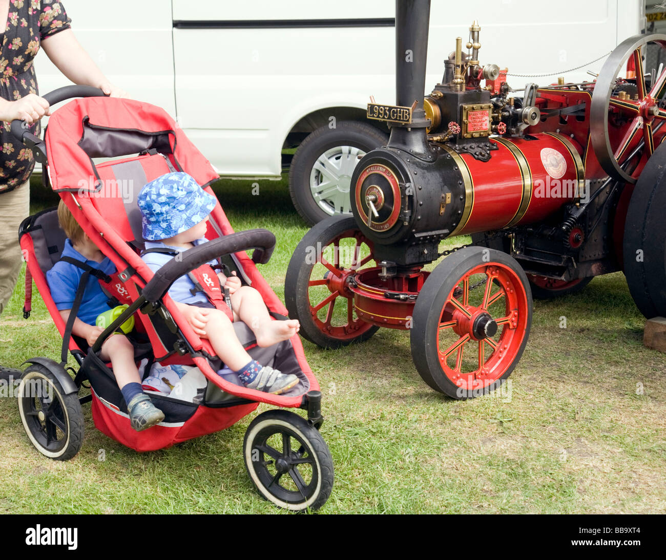 Two Toddlers looking at a small traction engine, Wallingford Classic Car Rally, Oxfordshire, UK Stock Photo
