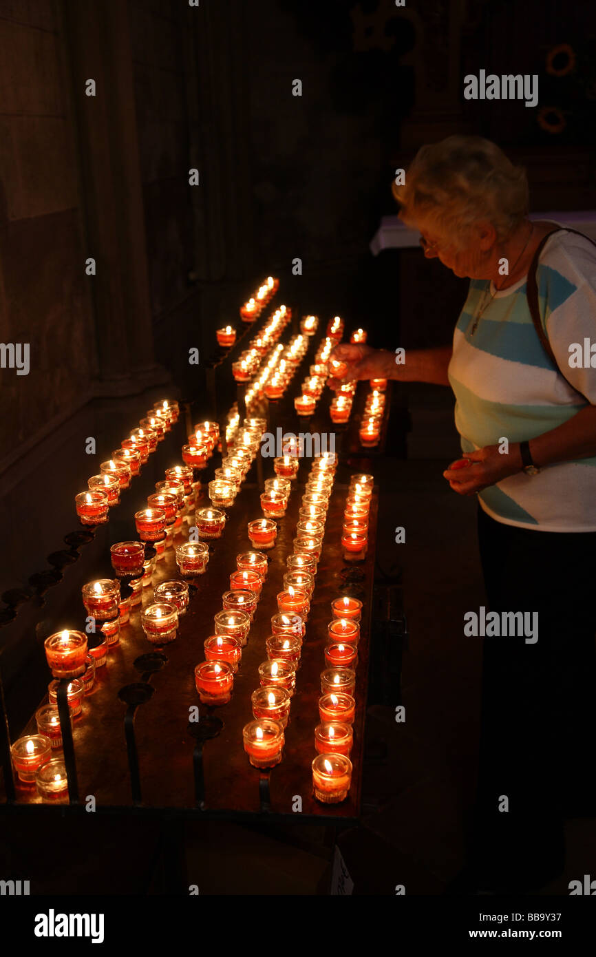 Woman lighting remembrance candles in church Stock Photo Alamy