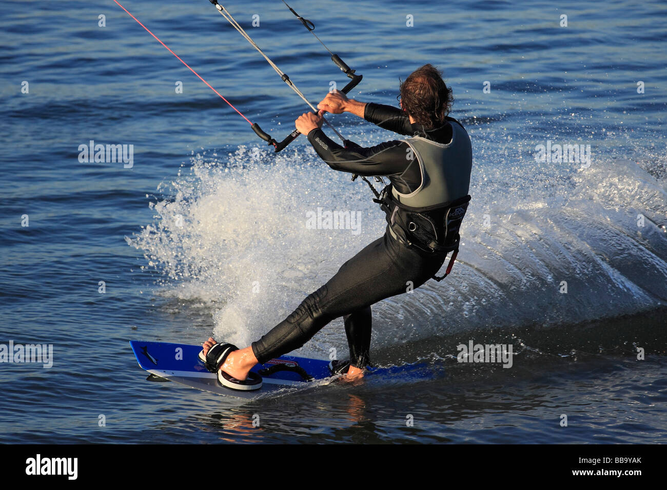 Kite Surfing. Kite Surfer creating huge wake as they move quickly atop