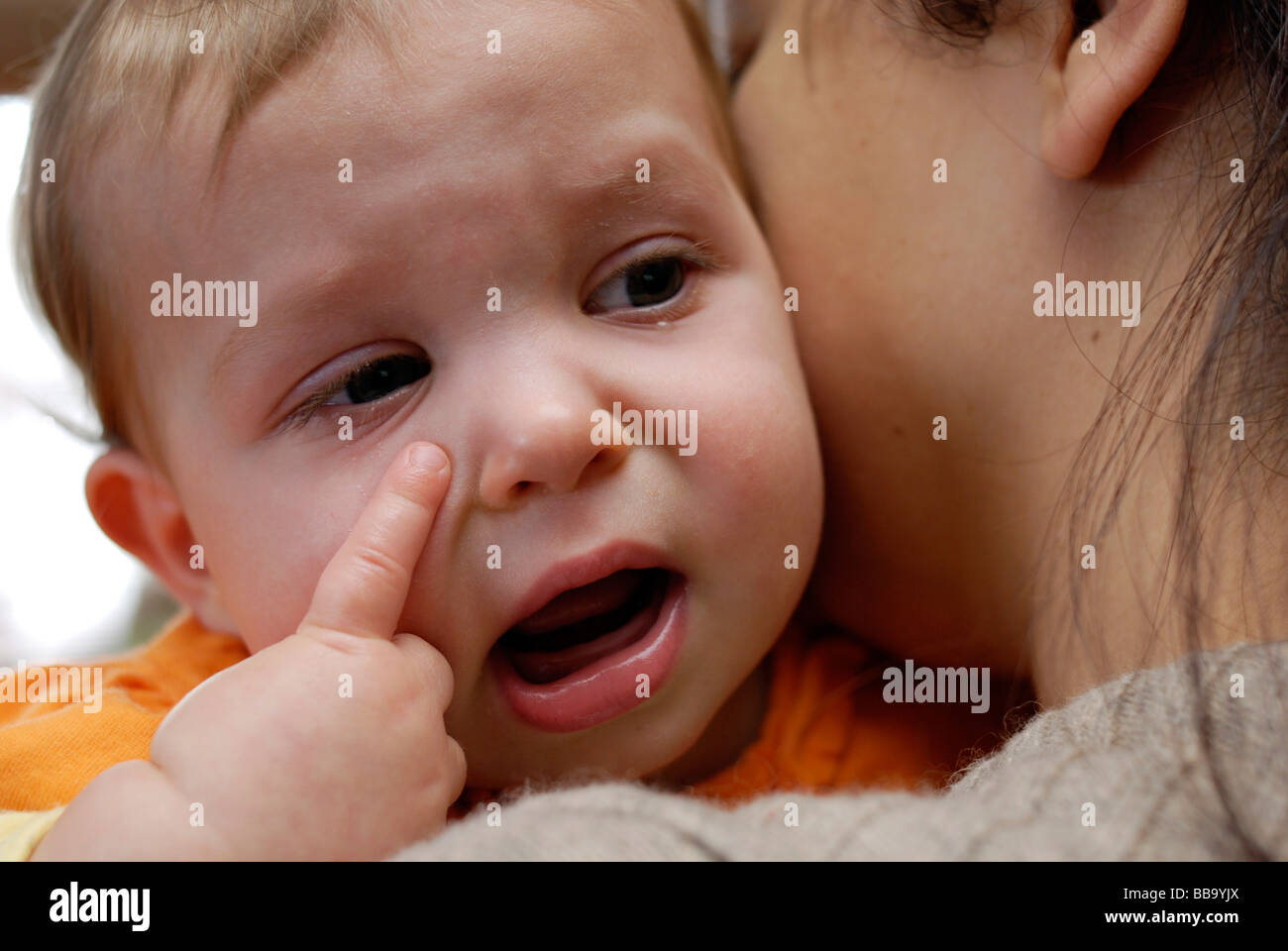 Mother soothing crying baby on her shoulder Stock Photo