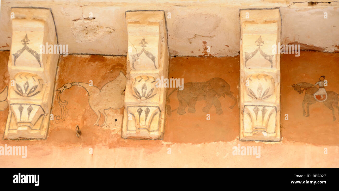 Painted frieze showing a bird eating a fish, a man on horseback, and other characters.  Amber Fort. Amber, Jaipur, Rajasthan, Re Stock Photo