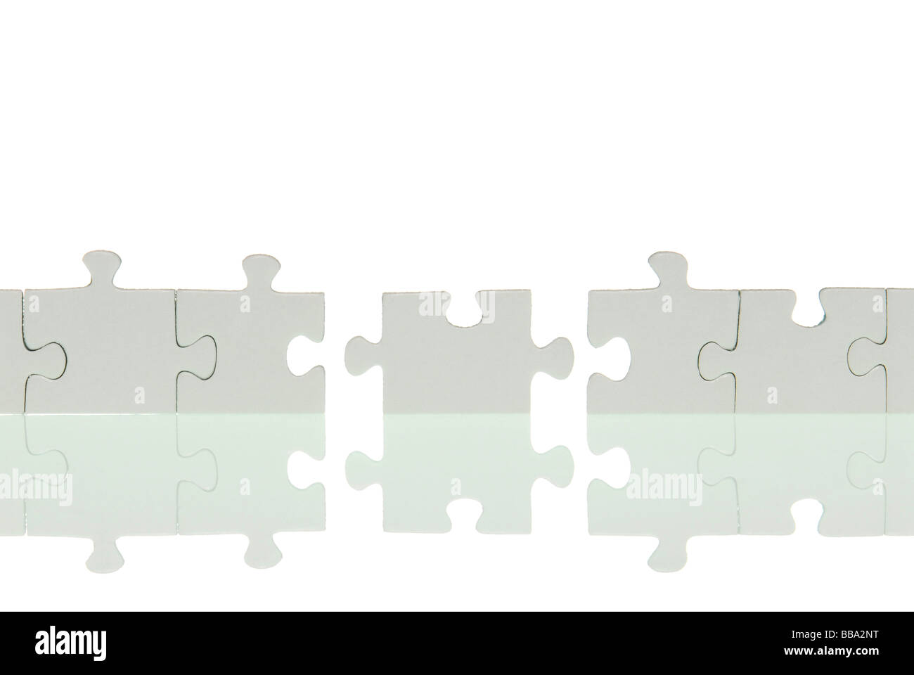 A row of puzzle pieces with a joining piece Stock Photo