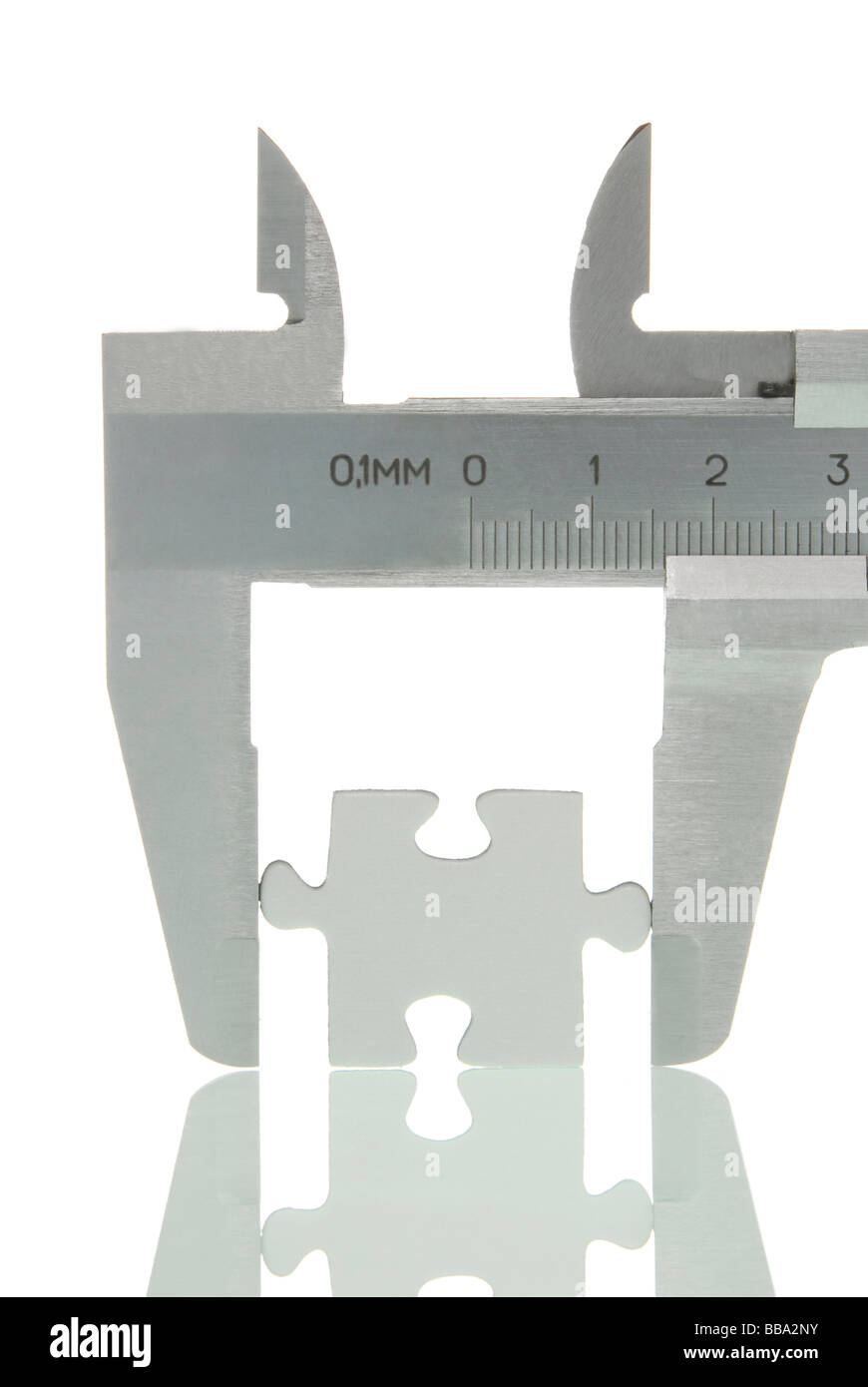 Calipers with a puzzle piece, symbolic image for analysis of a piece Stock Photo