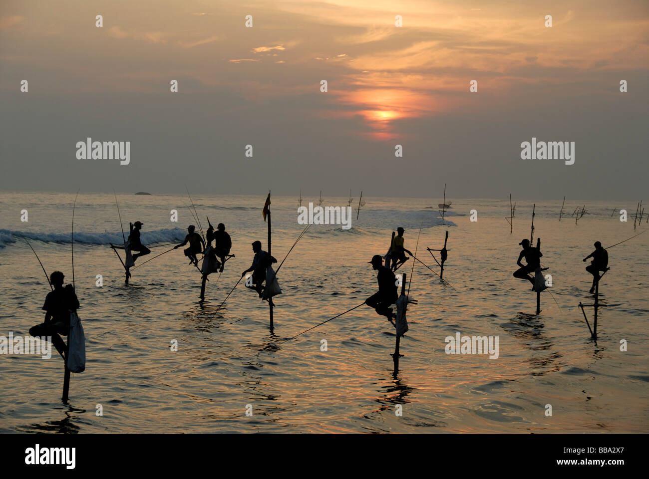 Stilt fishermen, sunset, fishermen on stilts fishing in the shallow