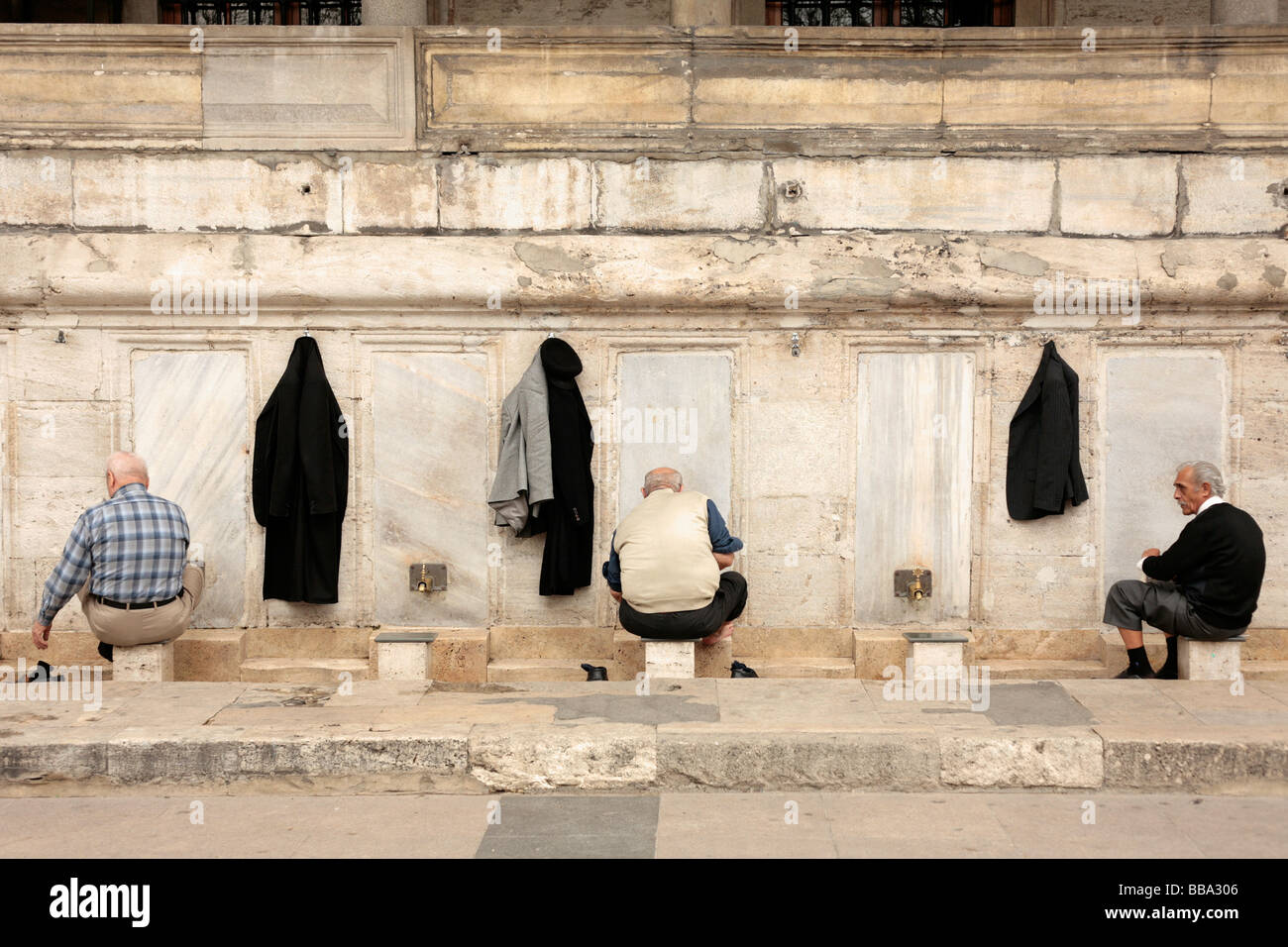 Men washing outside the Yeni Camii or New Mosque in Eminonu Istanbul Stock Photo