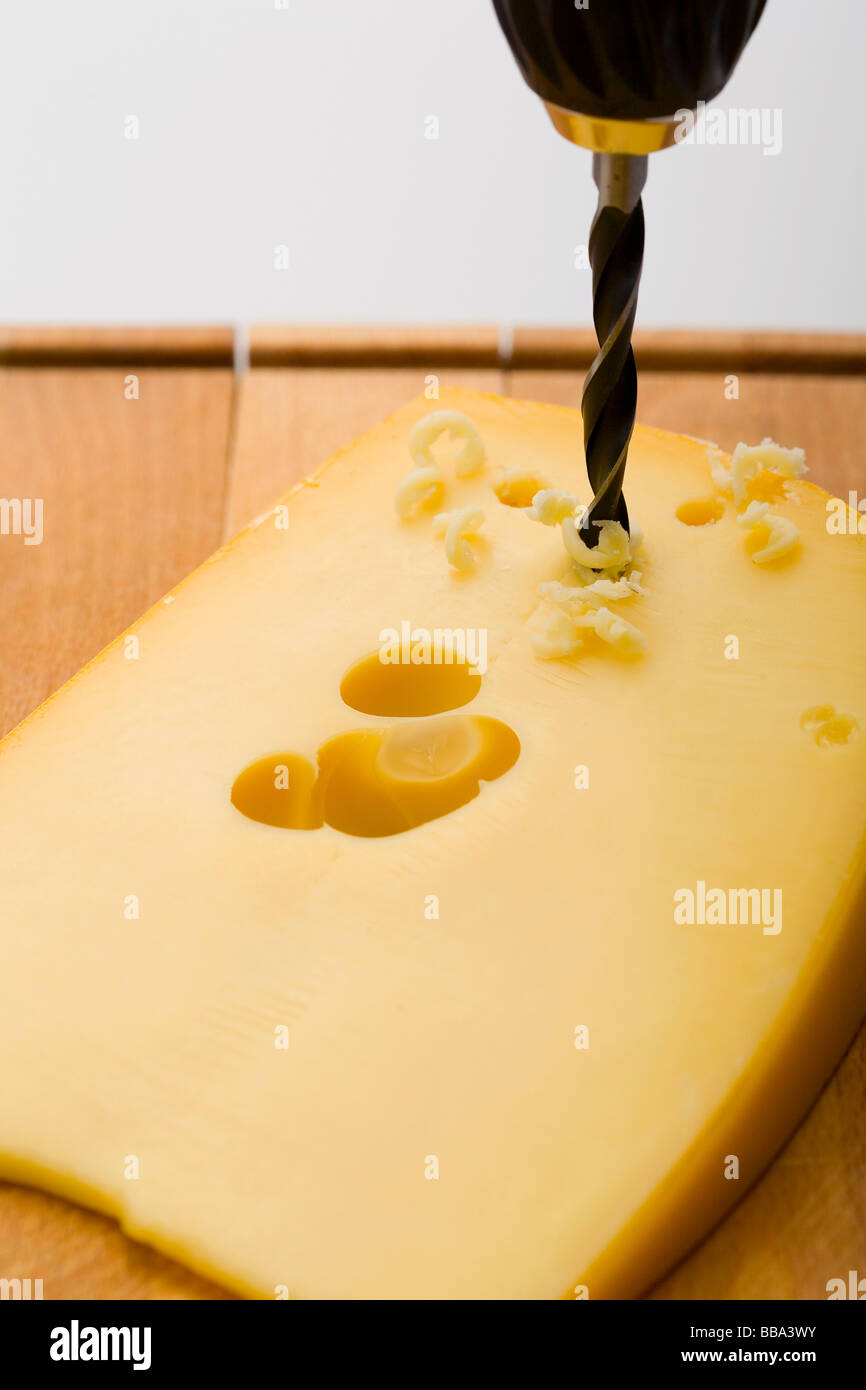 Drilling holes into cheese Stock Photo