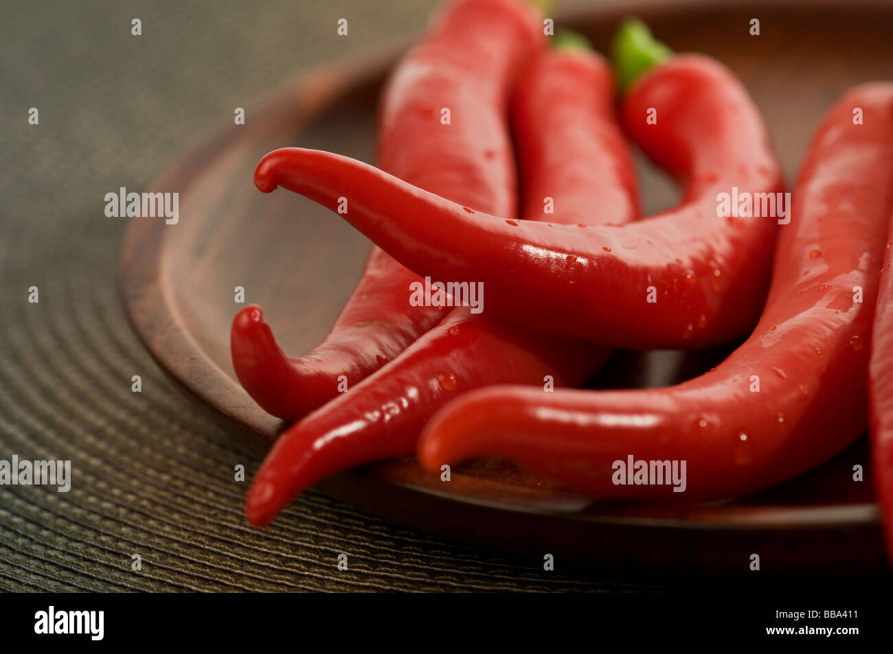 A bunch of red hot chillies in a wooden plate. Stock Photo