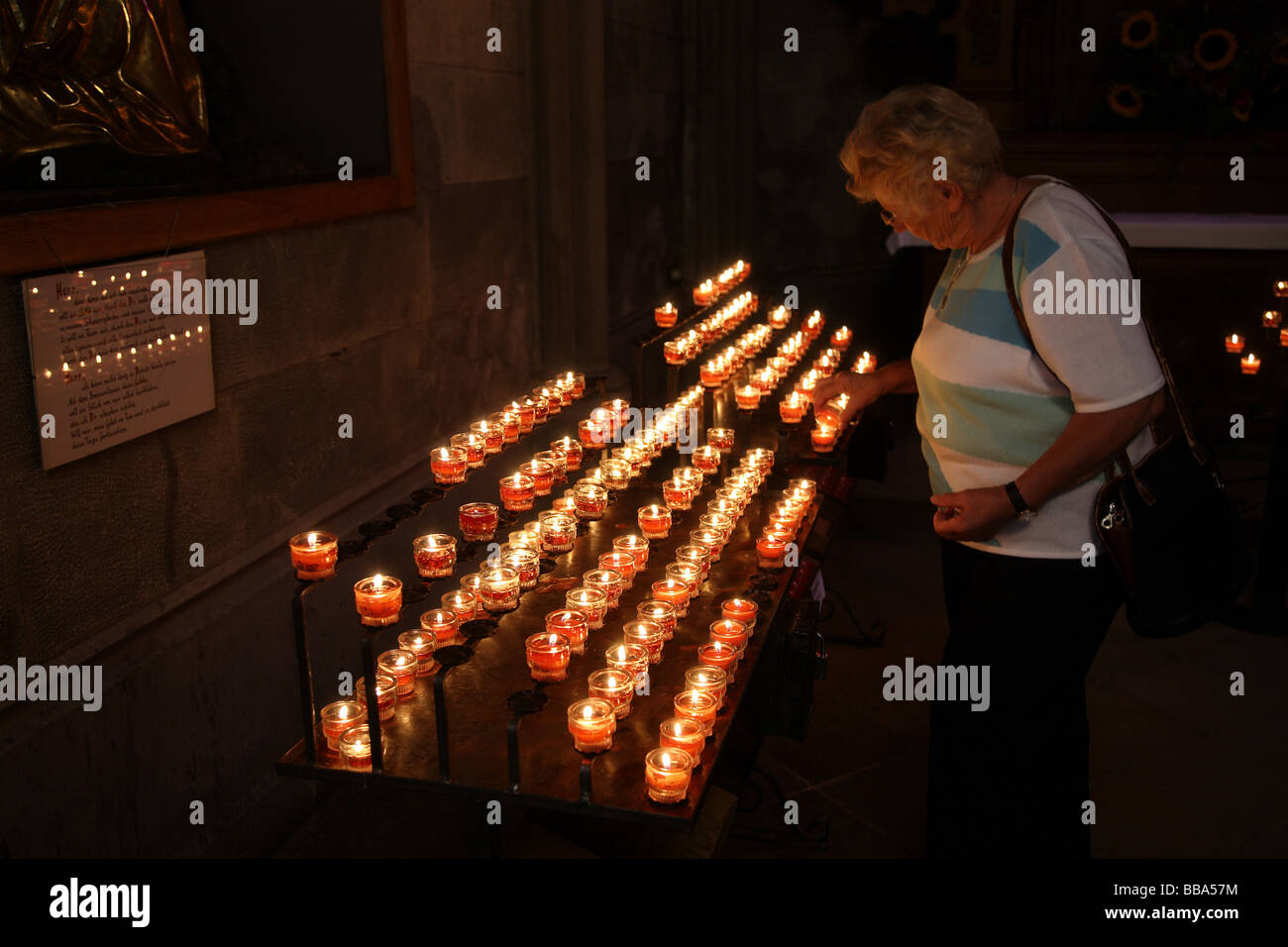 Woman lighting remembrance candles in church Stock Photo Alamy