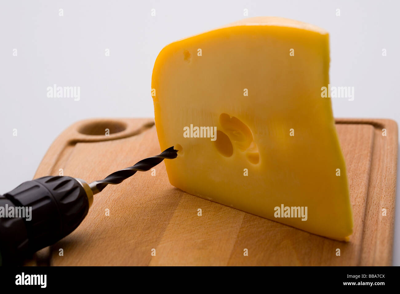 Drilling holes into cheese Stock Photo
