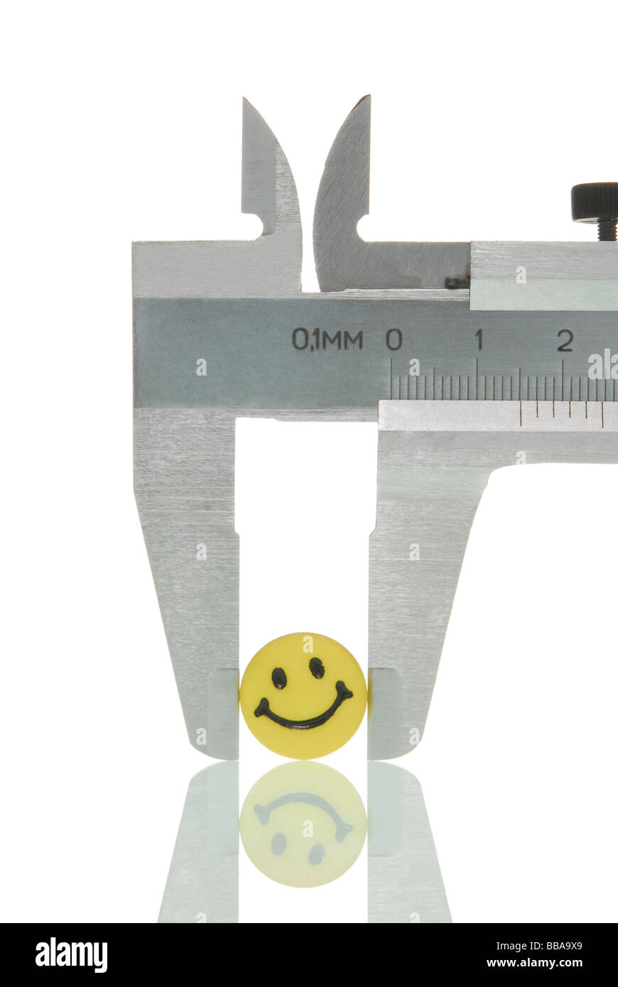 Calipers with a smiley face character, symbolic image for analysis of a human Stock Photo