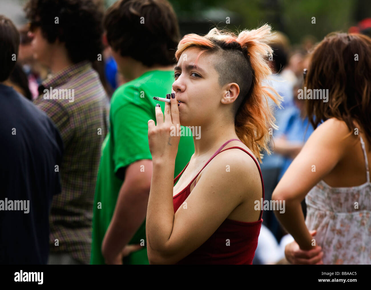 Smoking teen female with Mohawk haircut Stock Photo