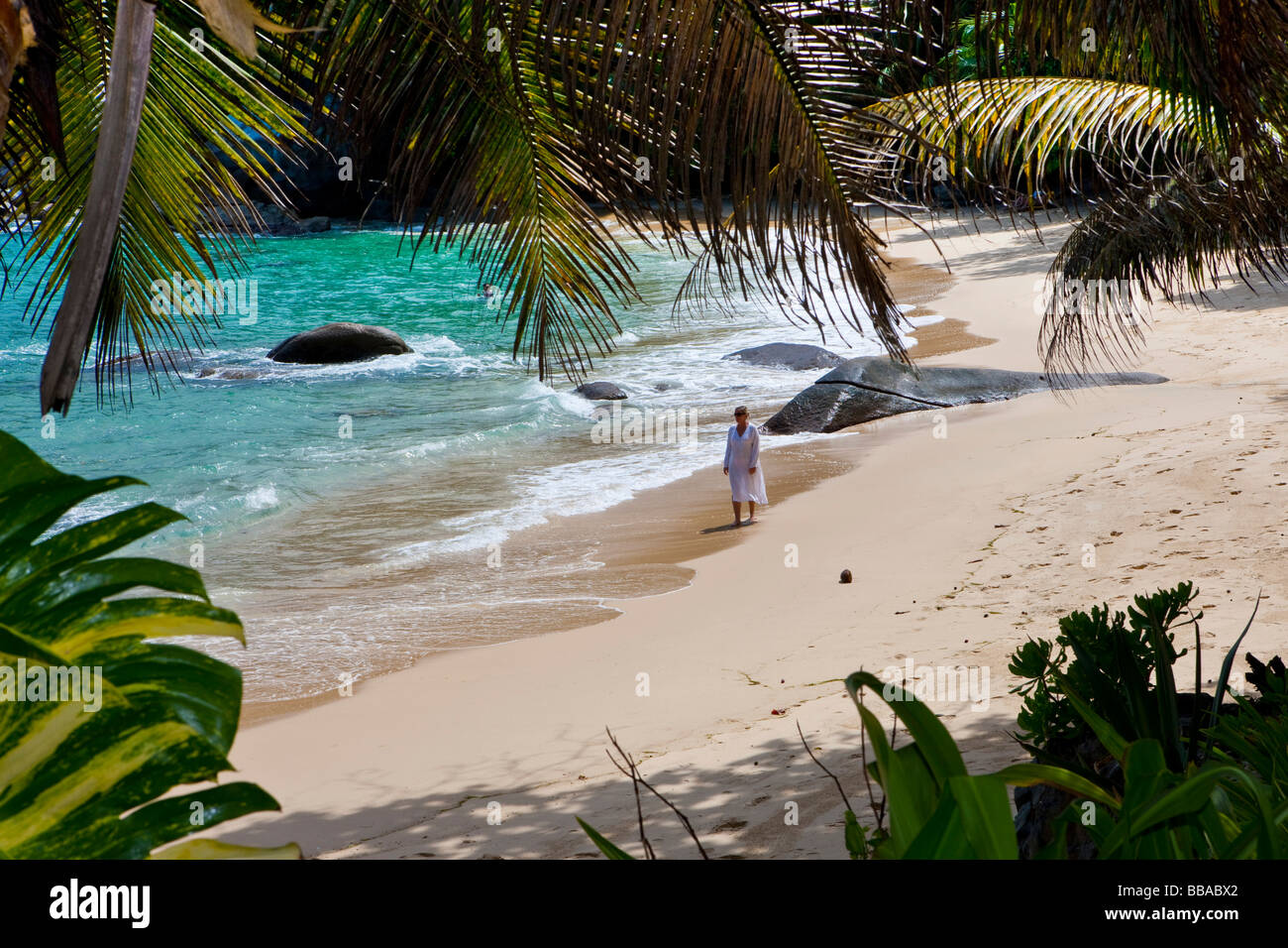 Woman walking along the beach wearing a tunic, Mahé Island, Seychelles, Indian Ocean, Africa Stock Photo