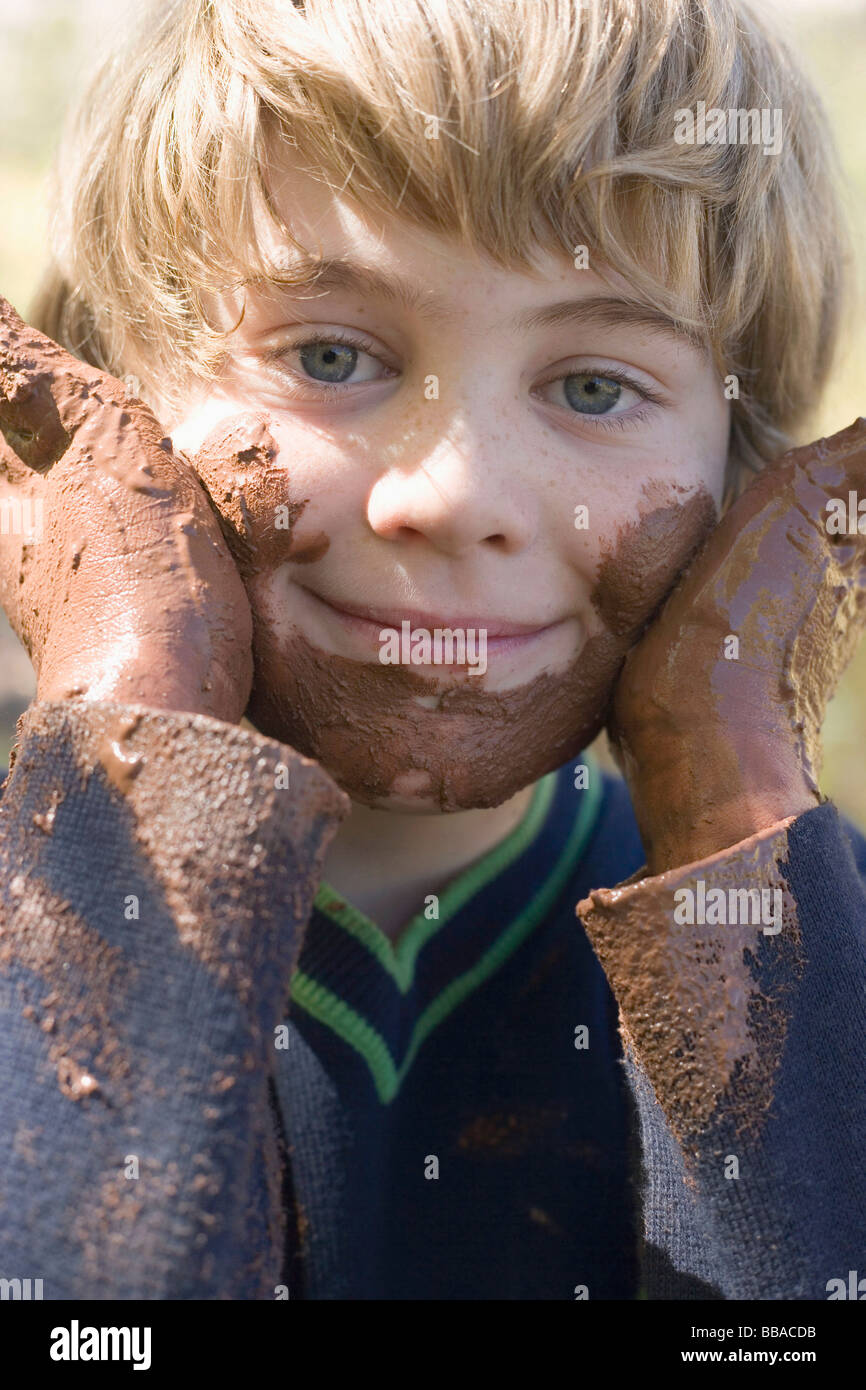 A young boy playing with mud Stock Photo