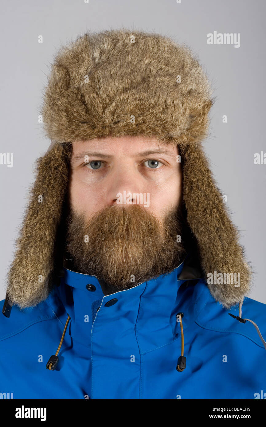 A man wearing warm clothing with long mustache hair covering his mouth