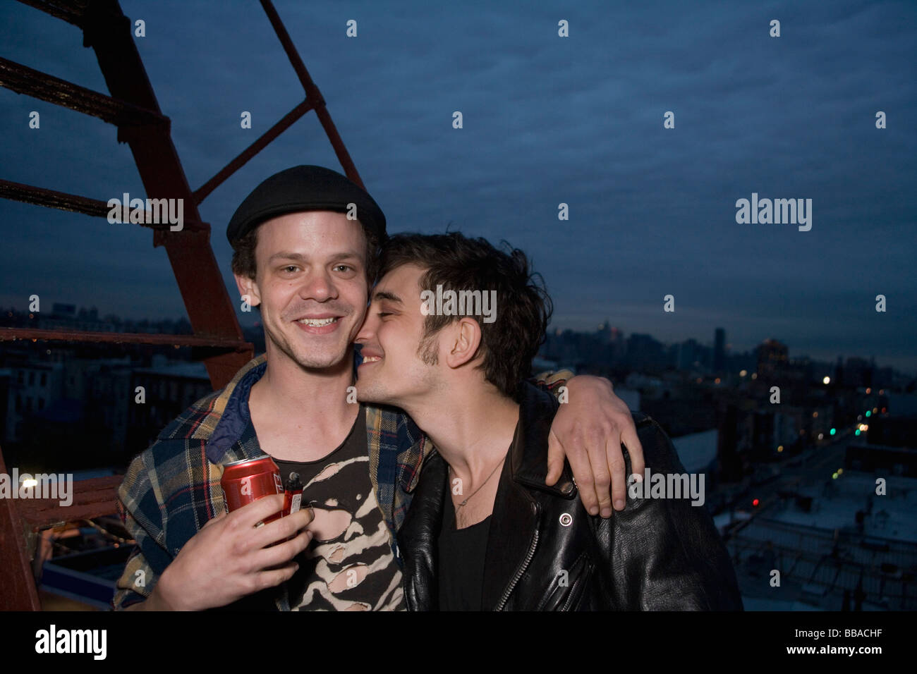 A young couple embracing on a fire escape Stock Photo